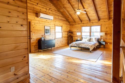 1 dormitorio con 1 cama en una cabaña de madera en Tranquility on White Tail Road en Deadwood