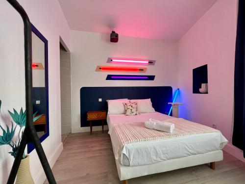 - une chambre avec un lit aux murs roses et bleus dans l'établissement Roma Reva: design et home cinema, à Nîmes
