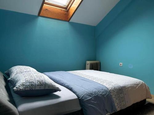 Schlafzimmer mit blauen Wänden und einem Bett mit Kissen in der Unterkunft Paradiso 5 in Bratunac