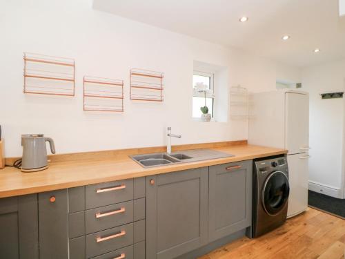 a kitchen with a sink and a washing machine at The Old Stables in Matlock