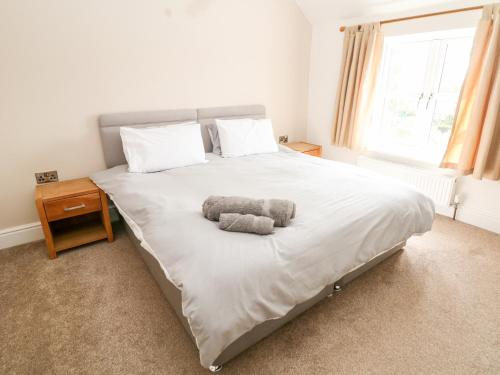 a bedroom with a bed with a stuffed animal on it at The Old Stables in Matlock