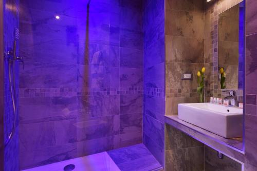 a bathroom with a sink and a shower with purple lighting at Hotel Patria in Rome