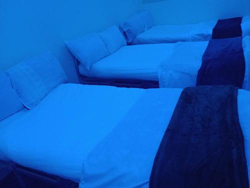 Habitación con 2 camas y sofá con luces azules en 3 Bedroom Apartment, en La Meca