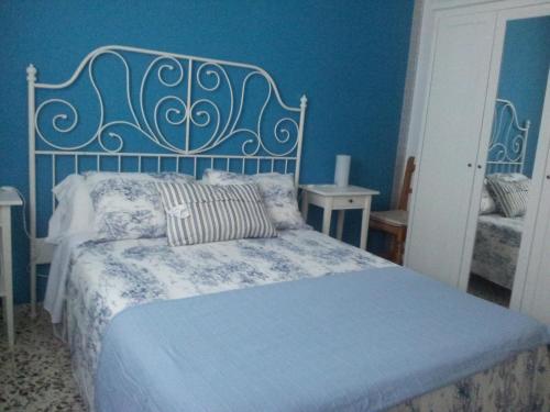 1 dormitorio con 1 cama con pared azul en Apartamentos Camping El Palmar, en El Palmar