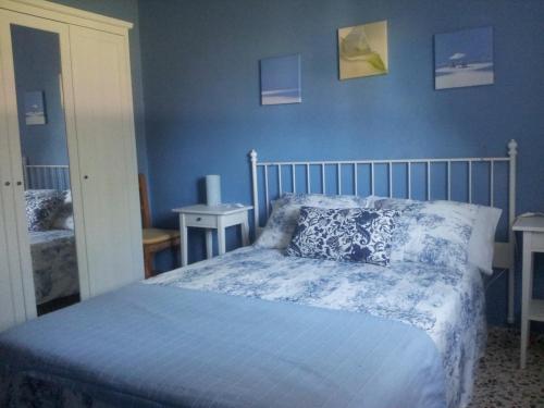 1 dormitorio con 1 cama con pared azul en Apartamentos Camping El Palmar, en El Palmar
