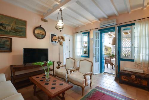 - un salon avec un canapé, des chaises et une table dans l'établissement Triantaros Artful Houses, à Triandáros