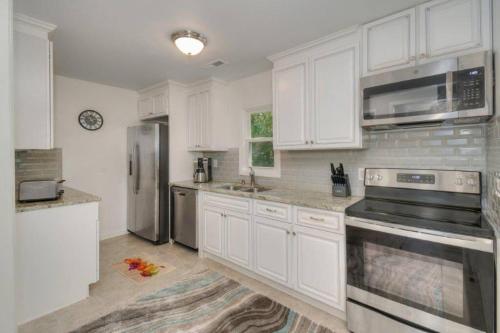 a kitchen with white cabinets and stainless steel appliances at Beach Lovin/sleeps 10/2 blocks to beach/pets ok in Myrtle Beach