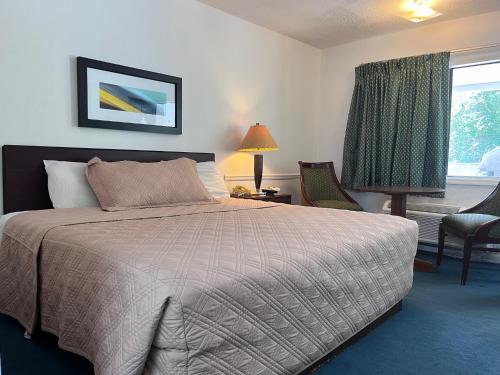 a bedroom with a large bed and a window at WINDTREE INN in Grove Hill
