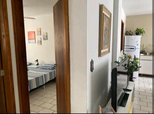 Zimmer mit einem Schlafzimmer mit einem Bett und einem TV in der Unterkunft Quarto em apartamento da Sandra in Balneário Camboriú