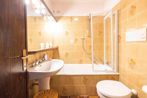 a bathroom with a sink and a tub and a toilet at SweetHome Chalet wifi garage in Santa Caterina Valfurva
