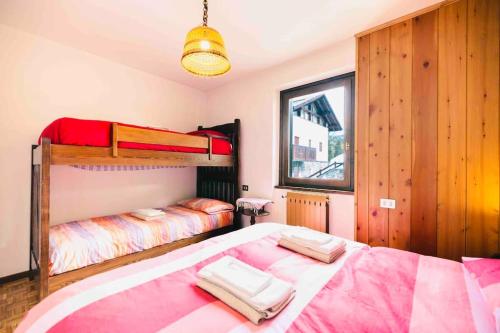 een slaapkamer met 2 stapelbedden en een raam bij Caldo appartamento vicino a Bormio + wifi + garage in Santa Caterina Valfurva
