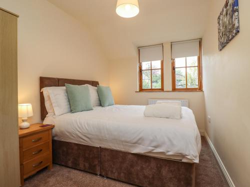 een slaapkamer met een groot bed en 2 ramen bij Stewart House in Wooler