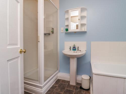 een badkamer met een wastafel en een douche bij Stewart House in Wooler