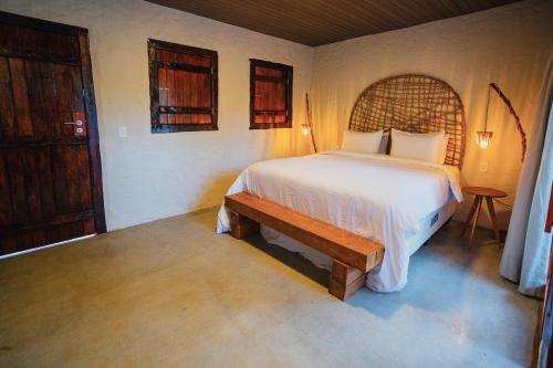 1 dormitorio con cama y banco. en Pousada Vilagoa en Coqueiro Sêco