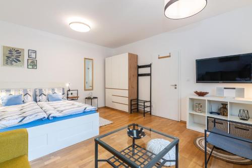 a living room with a bed and a tv at Apartment Giardino, Ika-Opatija in Opric