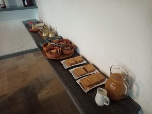 a table with plates of food and a jug on it at Oasi di Mastarone - Il vino e le Rose in Momperone