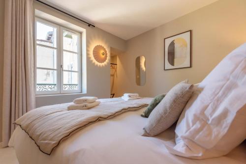 a bedroom with a large white bed with a window at Le Cosy Chic . Proche gare . Centre-ville Mâcon . Neuf . Climatisation . Design . Wifi . in Mâcon