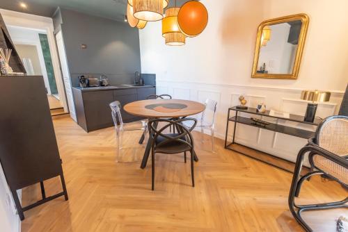 a kitchen and dining room with a table and chairs at Le Cosy Chic . Proche gare . Centre-ville Mâcon . Neuf . Climatisation . Design . Wifi . in Mâcon