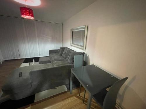 Xtra large 1 bedroom London Flat في Woolwich: غرفة معيشة مع أريكة وطاولة