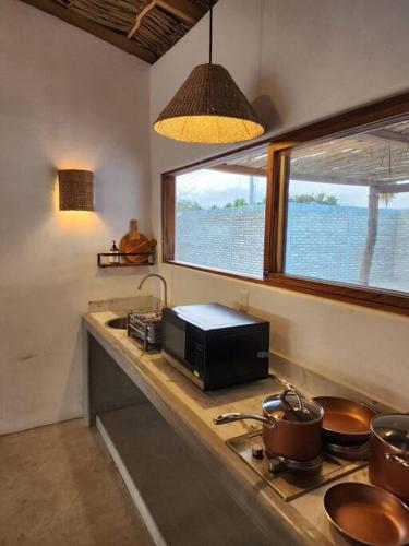 a kitchen counter with a microwave and a window at Exclusiva Casita frente al mar in Barra de Potosi