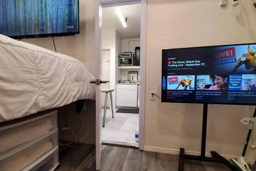 een slaapkamer met een flatscreen-tv aan de muur bij 1 Bedroom Mini Apartment in Otay Ranch in Chula Vista