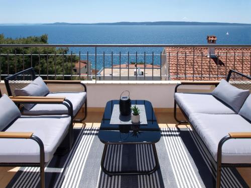 a balcony with couches and a table and the ocean at Villa Sirenis in Trogir