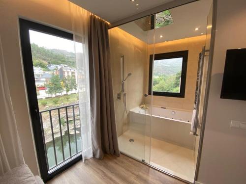 a bathroom with a shower and a large window at A PONTEVELLA Sobradelo, Alojamiento Boutique in Sobradelo