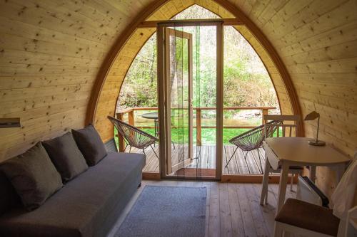 a room with a couch and a table and a window at Meža namiņi Sprīdīši in Tērvete