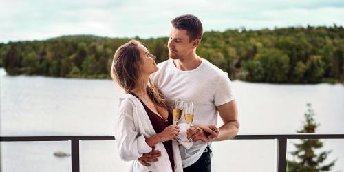 a man and woman standing on a balcony holding champagne glasses at Estérel Resort in Esterel