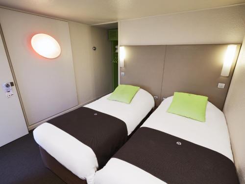 two beds in a small room with at Campanile Versailles Buc in Buc