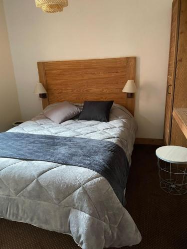 une chambre avec un grand lit avec une tête de lit en bois dans l'établissement Appartement Rés Cami Real, T2 cabine, 5 personnes, piscine intérieure, à Saint-Lary-Soulan