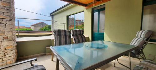 a glass table and chairs in a room with a window at Villa Gitta in Vela Luka