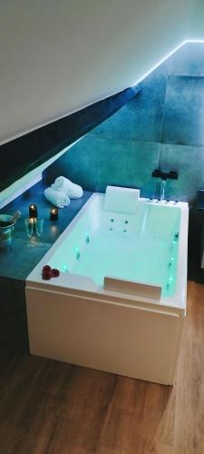 una vasca da bagno in una camera con parete blu di OPALENSIA a Thuin
