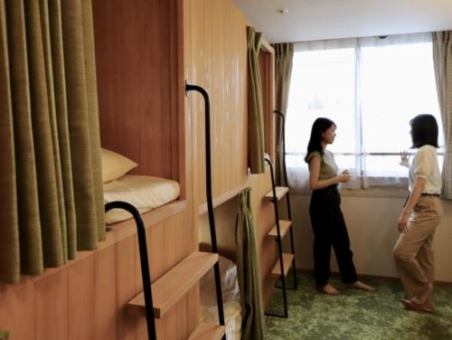 two women standing in a room with their beds at HataraColiving - Vacation STAY 22651v in Chichibu