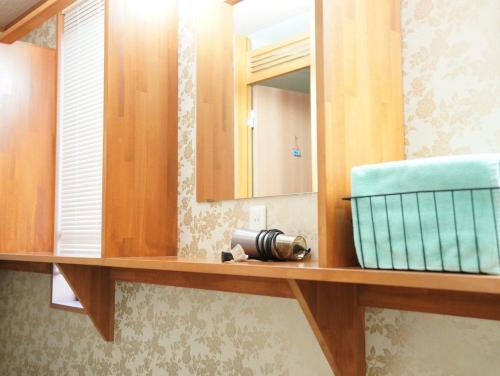 een badkamer met een spiegel en een camera op een plank bij HataraColiving - Vacation STAY 24095v in Chichibu