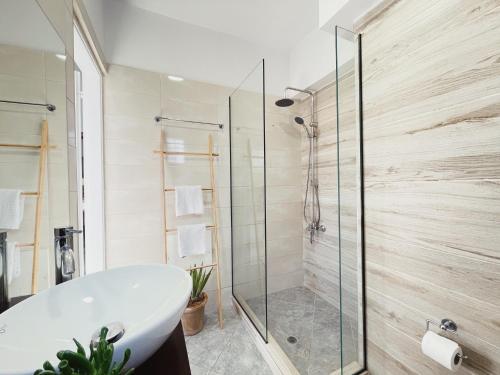 a bathroom with a tub and a glass shower at Miramare Apartments in Plataniás