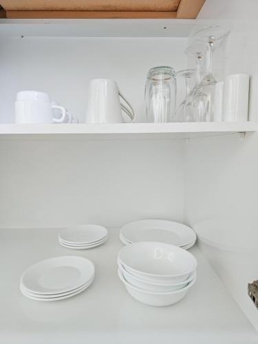 a shelf with plates and dishes on it at Captain Cook Motor Lodge in Gisborne
