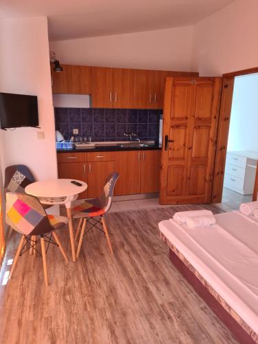 um quarto com uma cama, uma mesa e cadeiras em Къща за гости СТЕЛА em Primorsko
