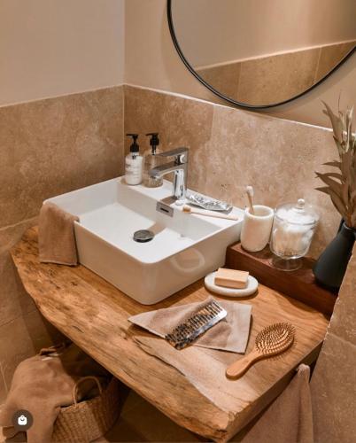 La salle de bains est pourvue d'un lavabo en bois et d'un miroir. dans l'établissement Mas le petit Paradou, à Paradou