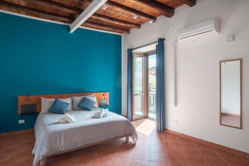 een slaapkamer met een blauwe muur en een bed bij Suk Ballarò House in Palermo