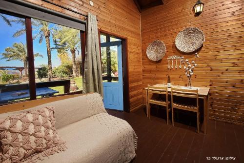 a bedroom with a table and a bed and a table and chairs at בקתה בתמרים in Moshav Ramot