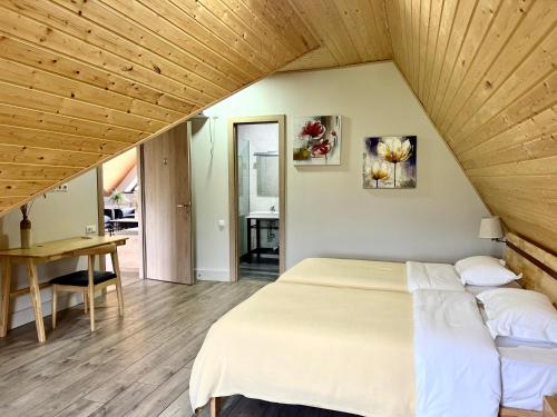 a bedroom with a large bed and a wooden ceiling at Begaso Family Winery in Kvareli