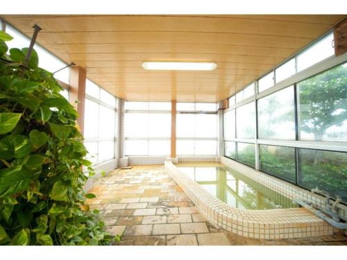 une chambre avec hamac dans un bâtiment avec fenêtres dans l'établissement Hotel Hayashi - Vacation STAY 49821v, à Beppu