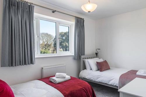 2 camas en una habitación con 2 ventanas en Beach Mews - Modern townhouse with patio and private parking en Kent