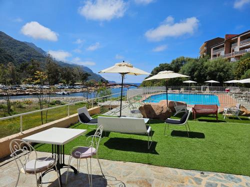 a patio with chairs and tables and a pool at Le Marina in Porto Ota