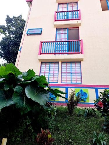a building with colorful windows and plants in front of it at The Gardens by Hope in Guatapé