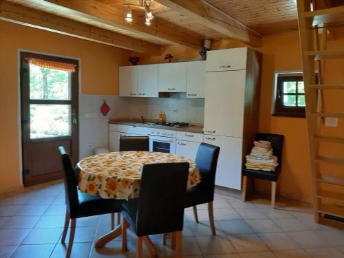 索卡的住宿－Cottage Lepena，带桌椅的厨房以及带桌子和桌子的厨房。