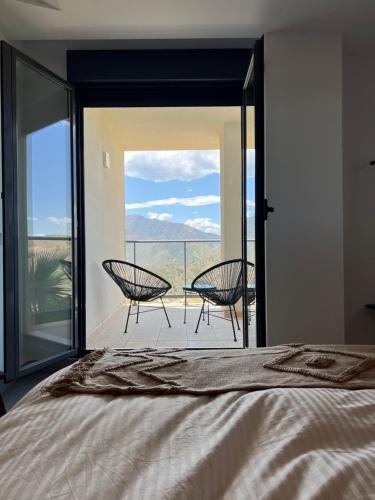 sypialnia z łóżkiem i balkonem z krzesłami w obiekcie Casa Hoyo Nueve - Alhaurín Golf - Alhaurín el Grande w mieście Alhaurín el Grande