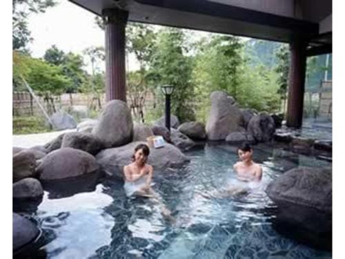 Un uomo e una donna in una pozza d'acqua di Gasthof Ami - Vacation STAY 96492v a Nikko
