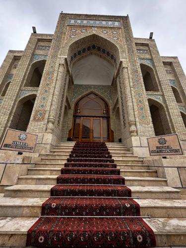 a large building with stairs leading to a door at SHAHRISTAN Plaza in Bukhara